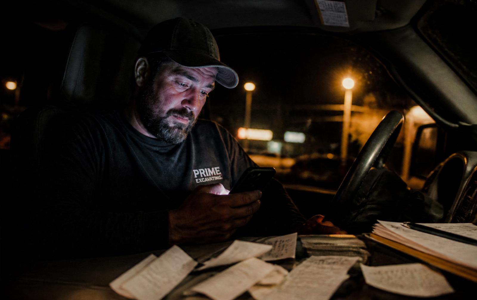 Contractor doing paperwork in his truck at night